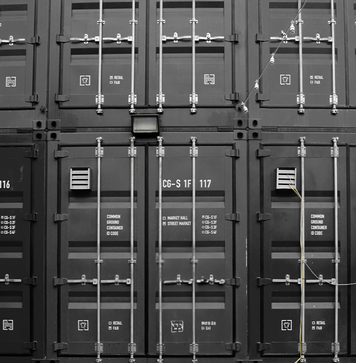 Stacked black cargo containers with identification markings,shipping fashion items